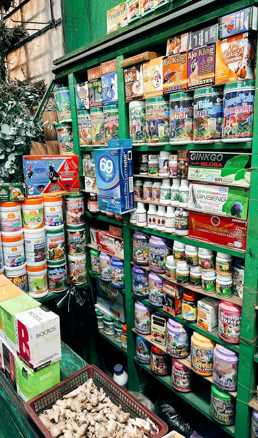 Półki wypełnione produktami zdrowotnymi i kosmetykami, z korzeniami imbiru z przodu.