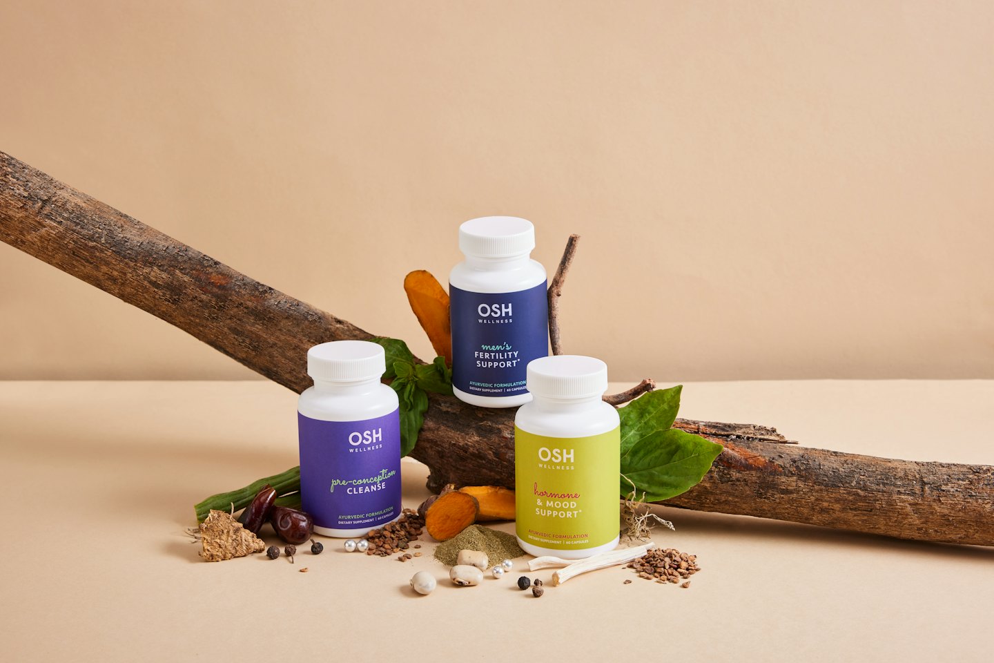 Butelki suplementów OSH WELLNESS ułożone z naturalnymi składnikami.